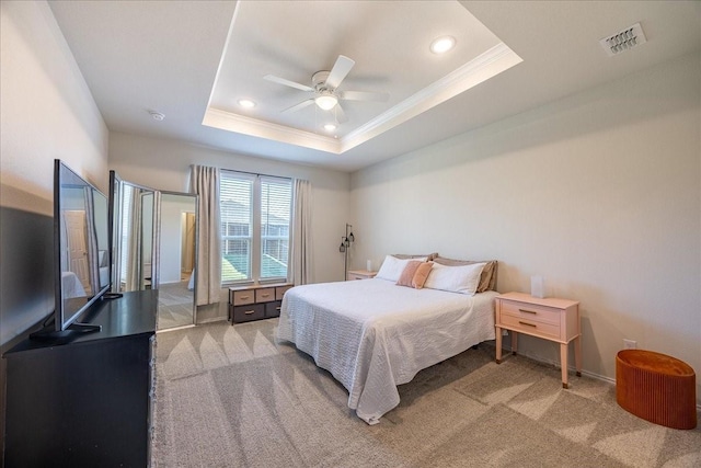 bedroom with ornamental molding, light carpet, recessed lighting, a tray ceiling, and ceiling fan