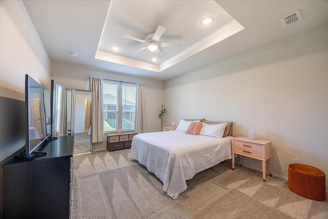 bedroom featuring a tray ceiling, recessed lighting, visible vents, ornamental molding, and light carpet