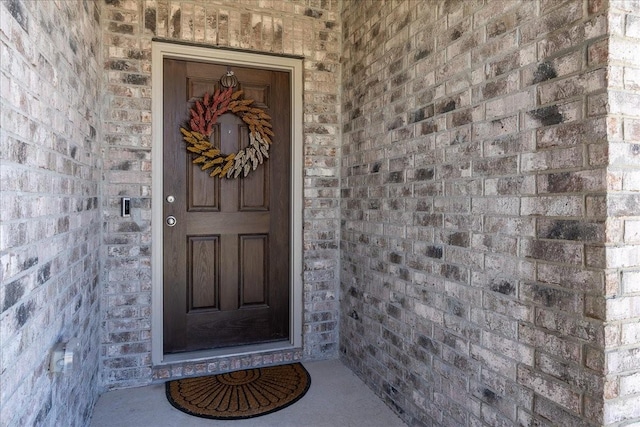 property entrance featuring brick siding