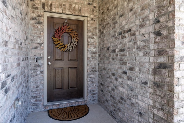 view of exterior entry featuring brick siding