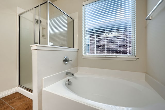 bathroom with tile patterned flooring, shower with separate bathtub, and a healthy amount of sunlight