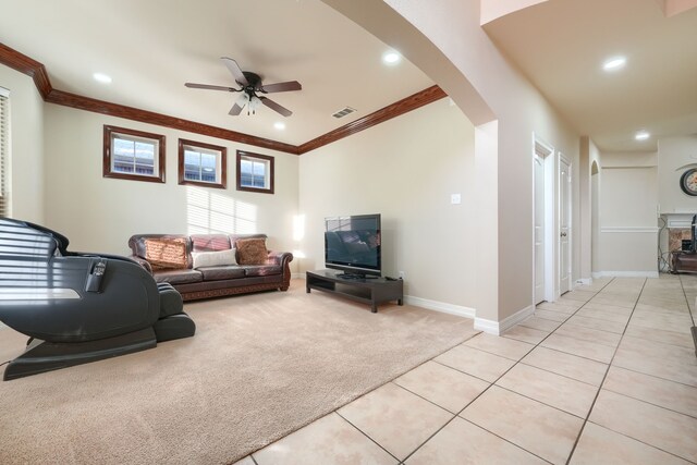 carpeted living room featuring a fireplace, ceiling fan, and crown molding