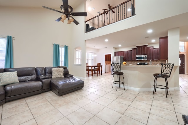 tiled living room with a towering ceiling and ceiling fan