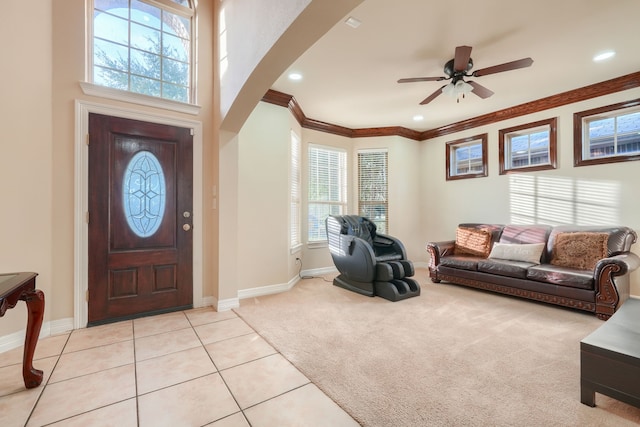 tiled foyer featuring a wealth of natural light, ceiling fan, and ornamental molding