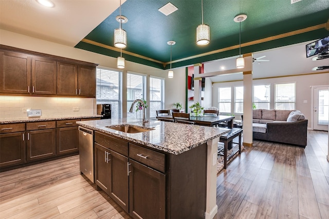 613 Hazeltine Rd, Red Oak, TX 75154 - kitchen with a tray ceiling, light wood-style floors, dark brown cabinetry, tasteful backsplash, and crown molding