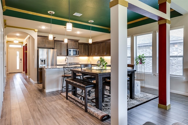 dining room with light hardwood / wood-style floors and crown molding