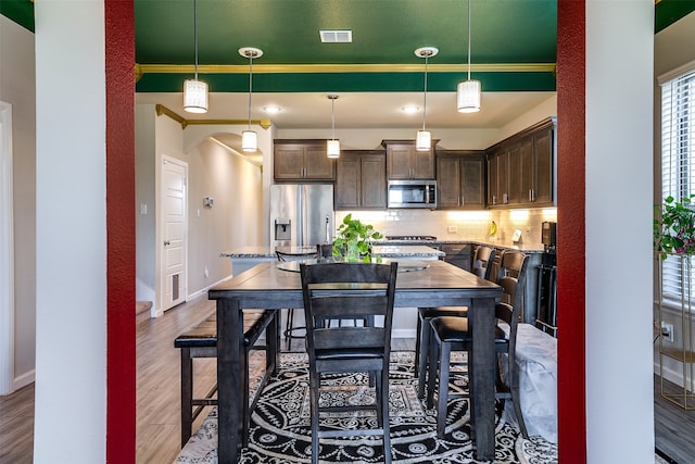 dining room featuring hardwood / wood-style flooring and crown molding