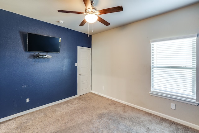 spare room featuring light carpet and ceiling fan