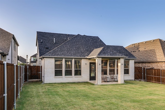 rear view of property with a lawn and a patio