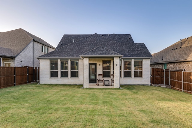 rear view of property featuring a yard and a patio