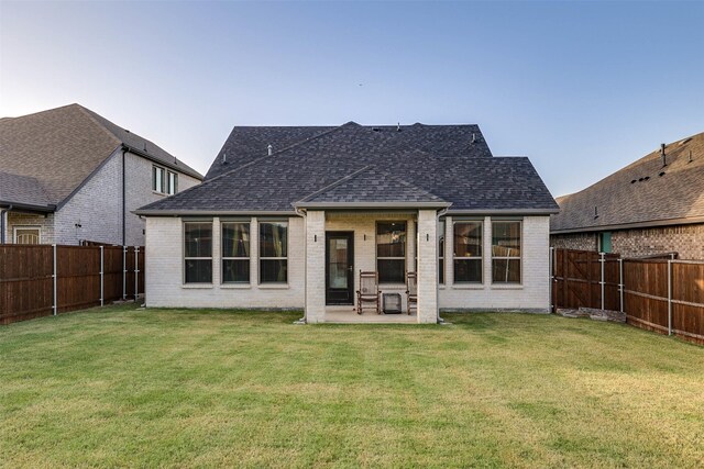 rear view of property featuring a yard and a patio