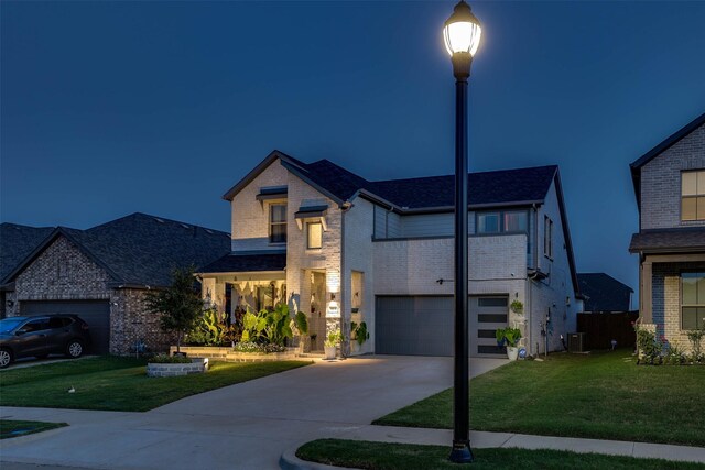 view of front of home with central AC unit, a front lawn, and a garage