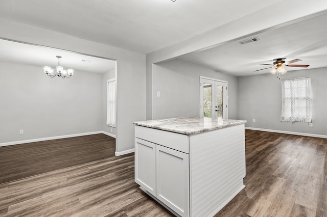 kitchen with hanging light fixtures, plenty of natural light, dark wood-type flooring, and white cabinets