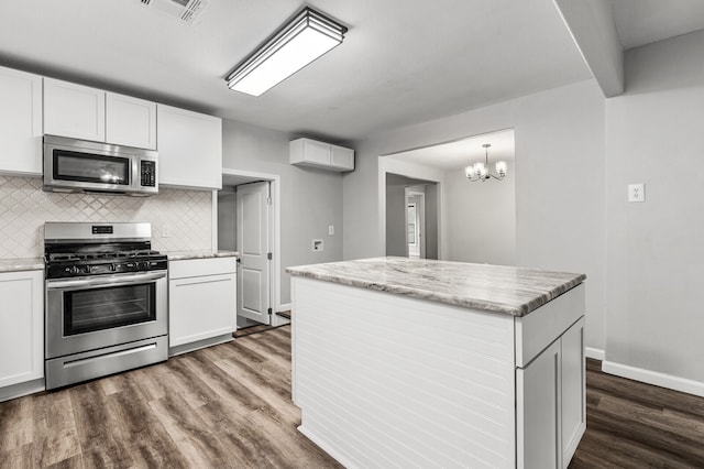 kitchen with white cabinets, decorative backsplash, stainless steel appliances, and dark hardwood / wood-style flooring