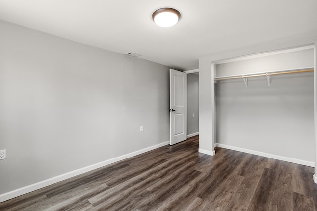 unfurnished bedroom featuring dark wood-type flooring and a closet