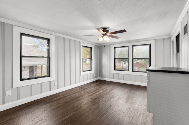 interior space with dark hardwood / wood-style flooring, a textured ceiling, a healthy amount of sunlight, and crown molding