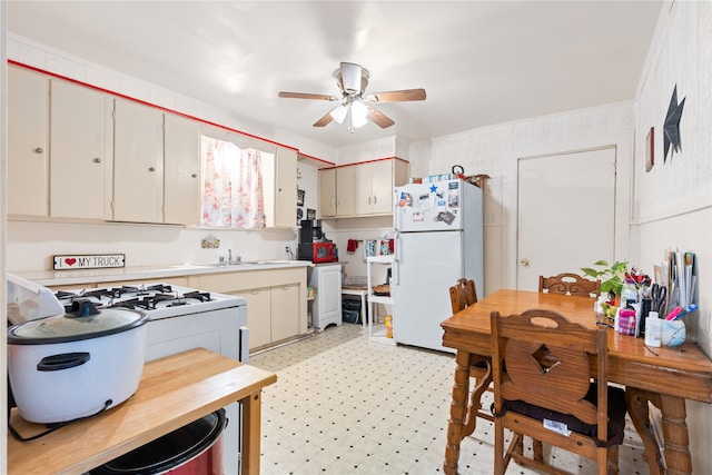 kitchen with cream cabinets, ceiling fan, white appliances, and sink