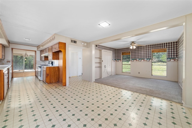 kitchen with white range oven, light carpet, ceiling fan, and plenty of natural light