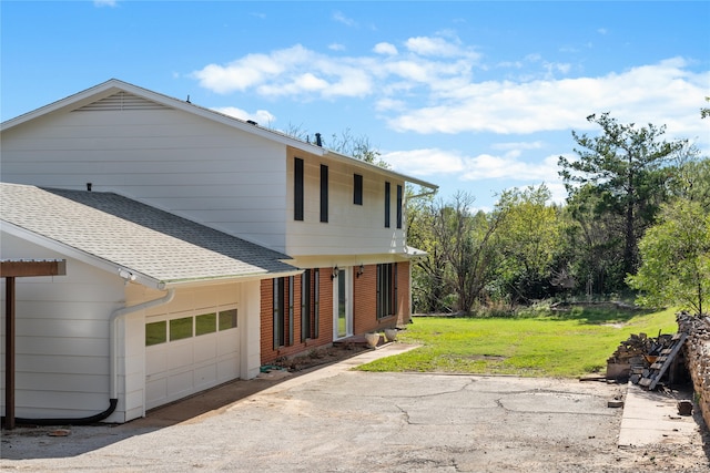 view of side of property with a garage and a lawn