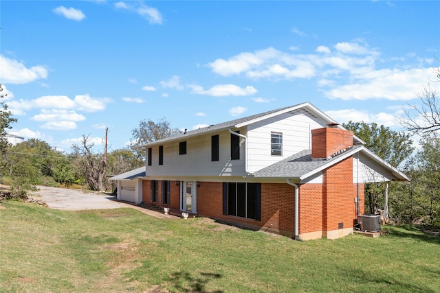 back of property featuring a garage and a yard