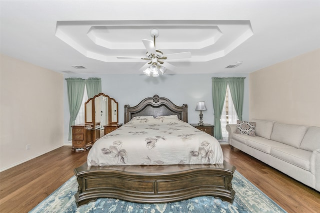 bedroom featuring a tray ceiling, hardwood / wood-style flooring, and ceiling fan