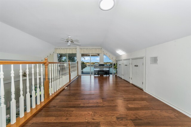 hallway with dark wood-type flooring and vaulted ceiling