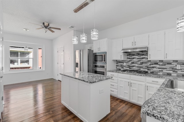 kitchen with white cabinets, appliances with stainless steel finishes, pendant lighting, and a center island