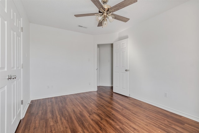 spare room featuring dark wood-type flooring and ceiling fan