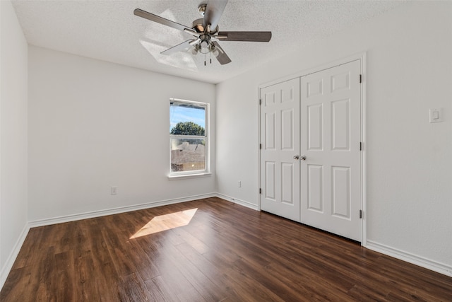 unfurnished bedroom featuring dark wood-type flooring, a closet, a textured ceiling, and ceiling fan