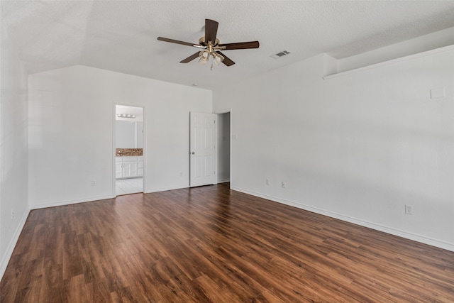 interior space with dark wood-type flooring, lofted ceiling, a textured ceiling, and ceiling fan