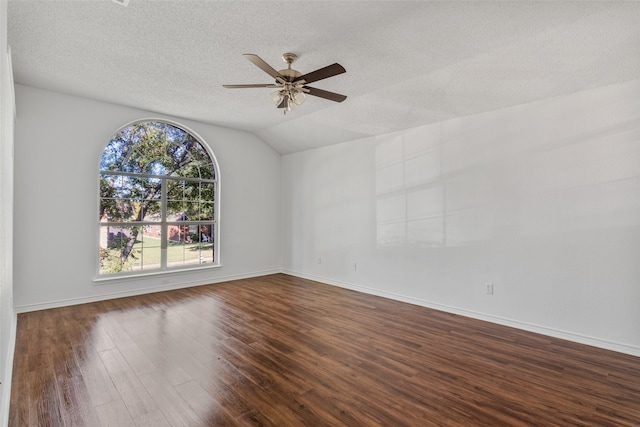 spare room with dark wood-type flooring, ceiling fan, a textured ceiling, and vaulted ceiling