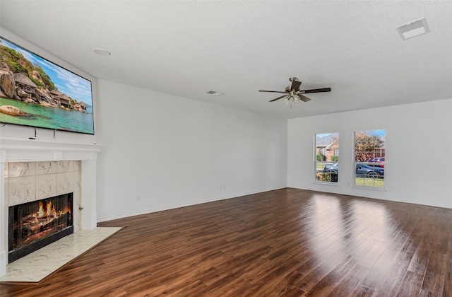 unfurnished living room featuring hardwood / wood-style floors, a fireplace, a textured ceiling, and ceiling fan