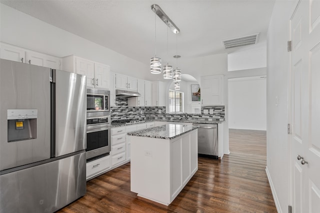 kitchen with a kitchen island, white cabinetry, appliances with stainless steel finishes, and hanging light fixtures