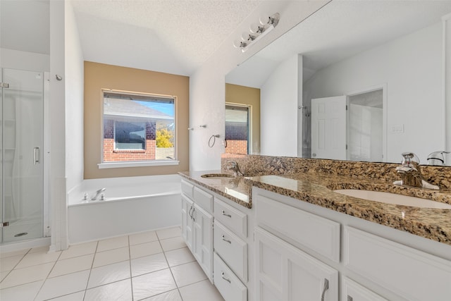 bathroom with vanity, a textured ceiling, tile patterned floors, and plus walk in shower