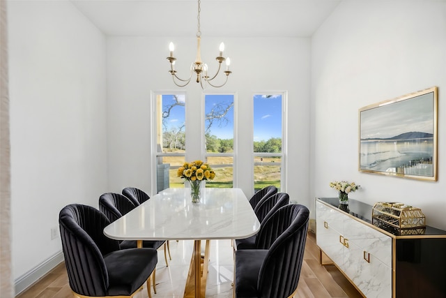 dining area featuring light wood-type flooring and a notable chandelier