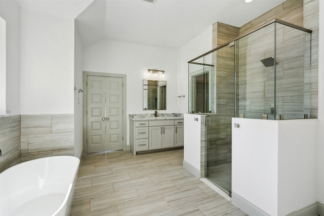 bathroom with shower with separate bathtub, vanity, and lofted ceiling