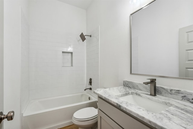 full bathroom with vanity, tiled shower / bath combo, and toilet