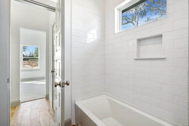 bathroom featuring shower / tub combination, hardwood / wood-style flooring, and plenty of natural light