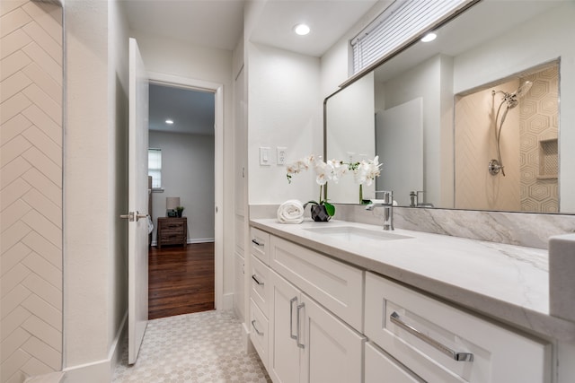 bathroom with walk in shower, vanity, and hardwood / wood-style flooring