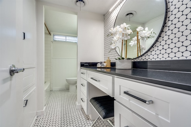 full bathroom featuring toilet, vanity, and  shower combination