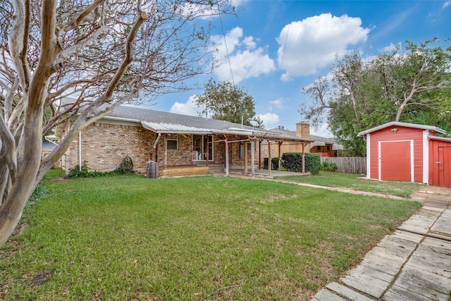 rear view of house featuring a garage, a yard, and a storage shed