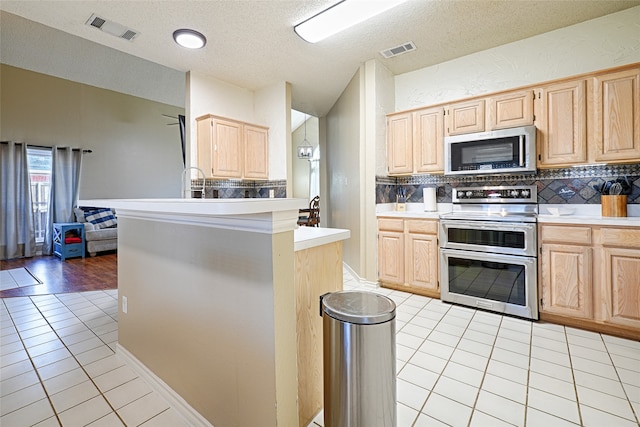 kitchen featuring light brown cabinets and stainless steel appliances