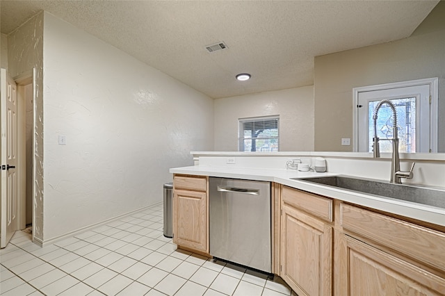 kitchen featuring light brown cabinetry, stainless steel dishwasher, plenty of natural light, and sink