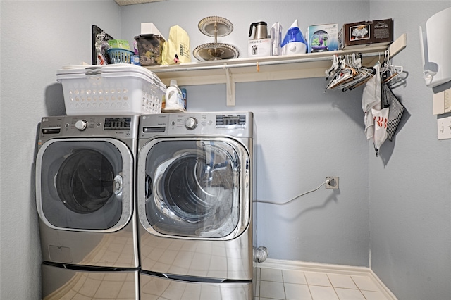 laundry area featuring washing machine and dryer and light tile patterned floors