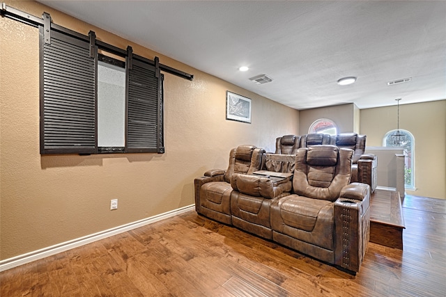 cinema featuring hardwood / wood-style floors and a barn door