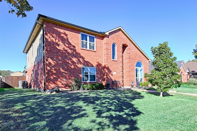 back of house with a lawn and central AC unit