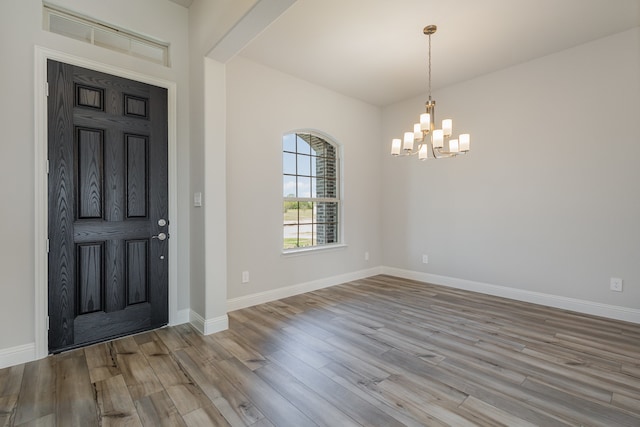 foyer with light wood-type flooring and a notable chandelier