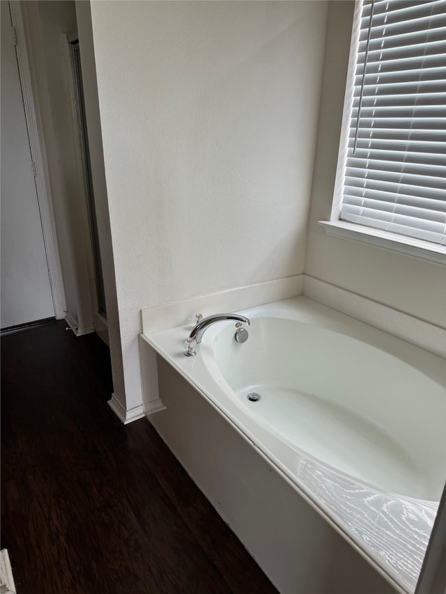 bathroom featuring hardwood / wood-style flooring and a bathing tub