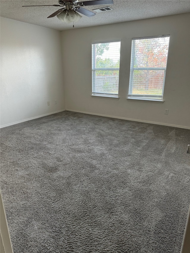 spare room with carpet flooring, ceiling fan, and a textured ceiling