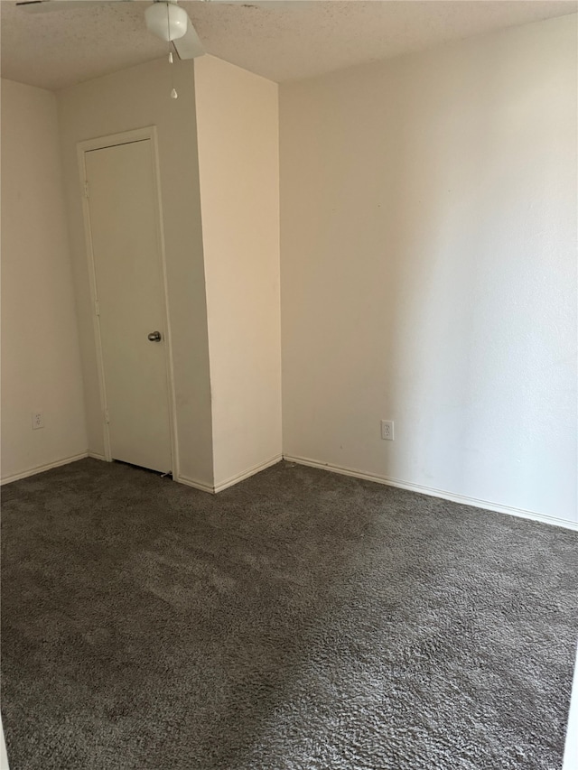 carpeted empty room with ceiling fan and a textured ceiling